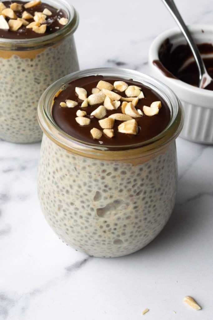 2 jars of chia pudding topped with chocolate and peanuts.