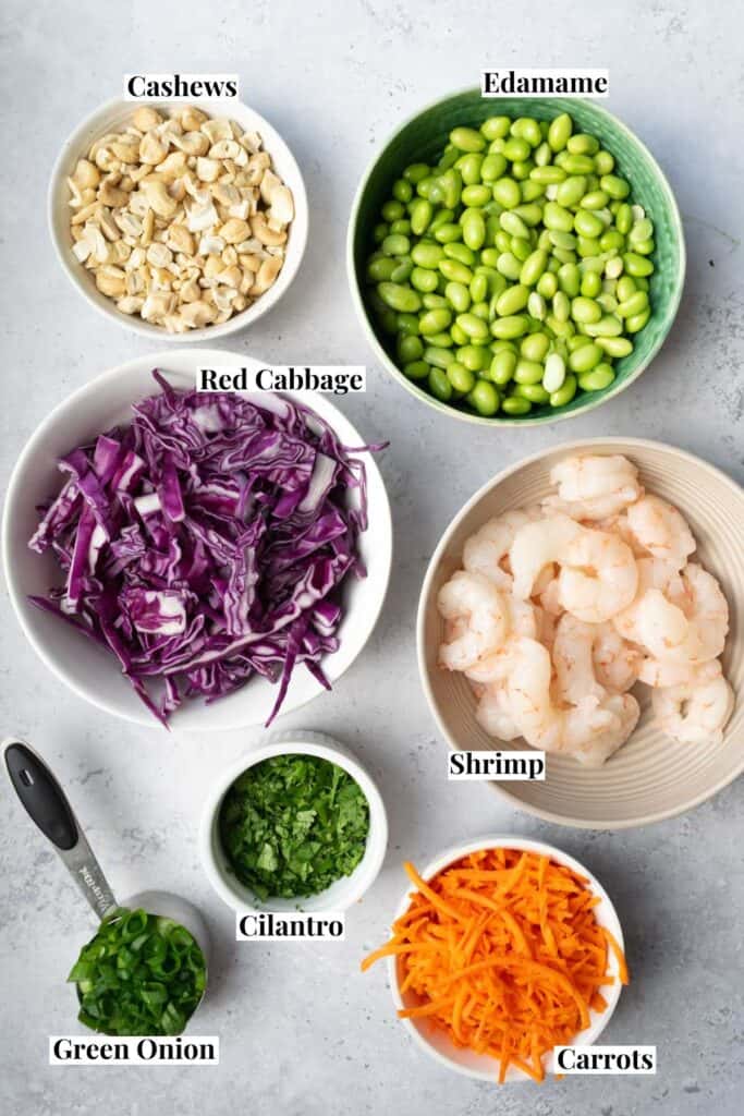 salad ingredients in bowls and measuring cups.