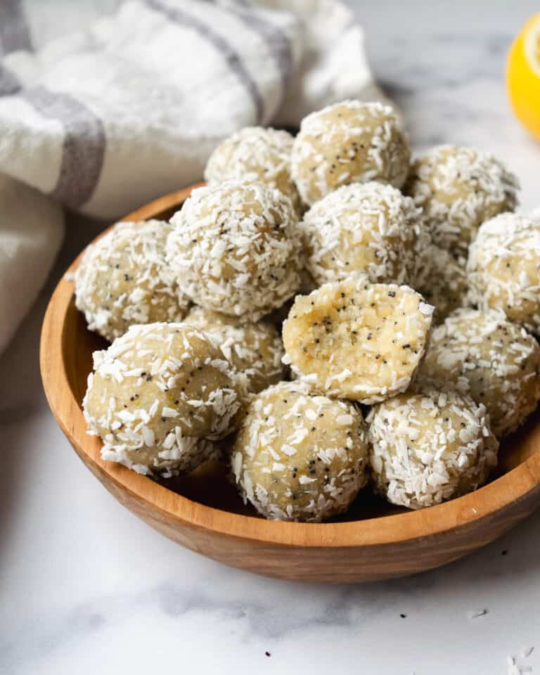 wooden bowl filled with lemon coconut poppy seed balls.