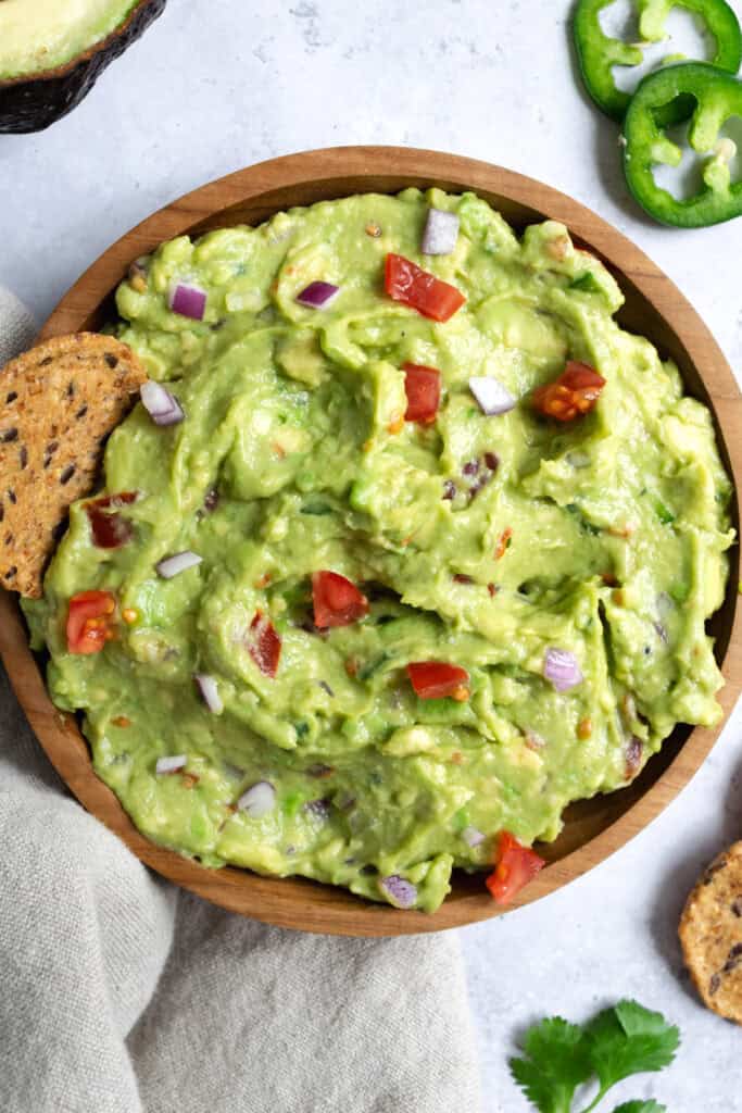 a bowl of guacamole with crackers.